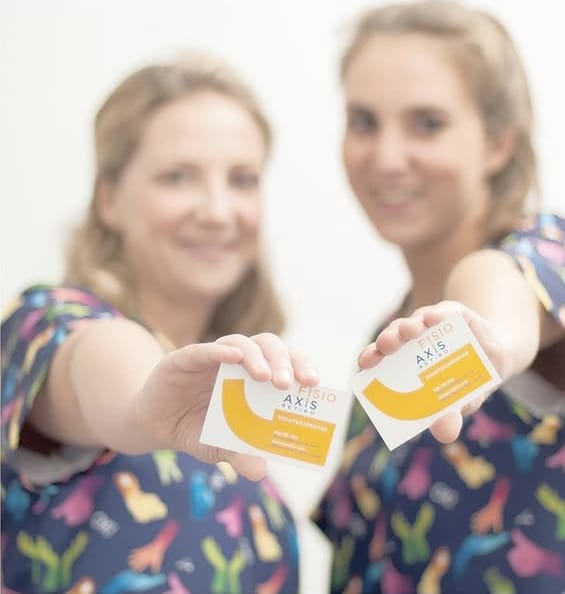 Equipo de FisioAxis mostrando tarjetas de presentación